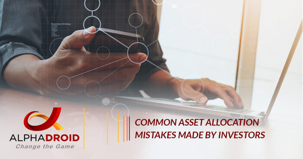 hand holding phone and other hand on laptop keyboard